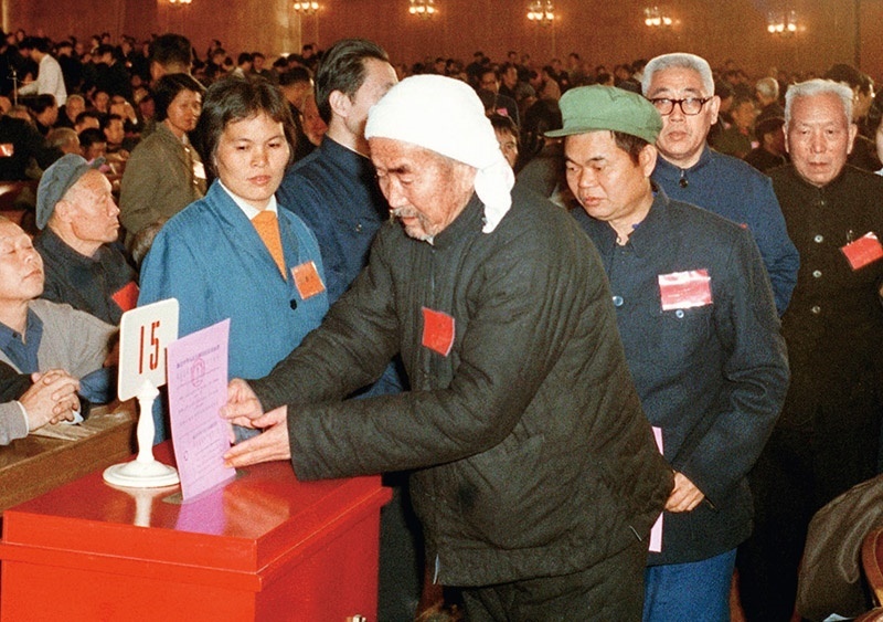 我國現行憲法于1982年12月4日由第五屆全國人大第五次會議通過并公布施行。根據改革開放和社會主義現代化建設的實踐和發(fā)展，全國人大于1988年、1993年、1999年、2004年、2018年先后5次作出必要的、也是十分重要的修正。圖為出席第五屆全國人民代表大會第五次會議的代表投票表決《中華人民共和國憲法》（資料照片）。 新華社發(fā)