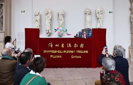 2月10日，在位于法國巴黎埃菲爾鐵塔附近的“建筑與遺產之城”博物館，觀眾欣賞漳州布袋木偶戲。新華社記者高靜攝