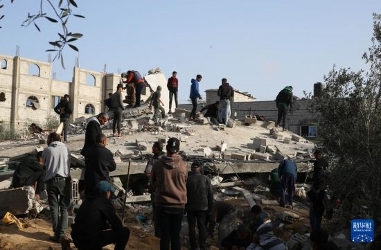  3月3日，在加沙地帶南部城市拉法，人們查看被以軍空襲破壞的建筑。新華社發(fā)（哈立德·奧馬爾攝）