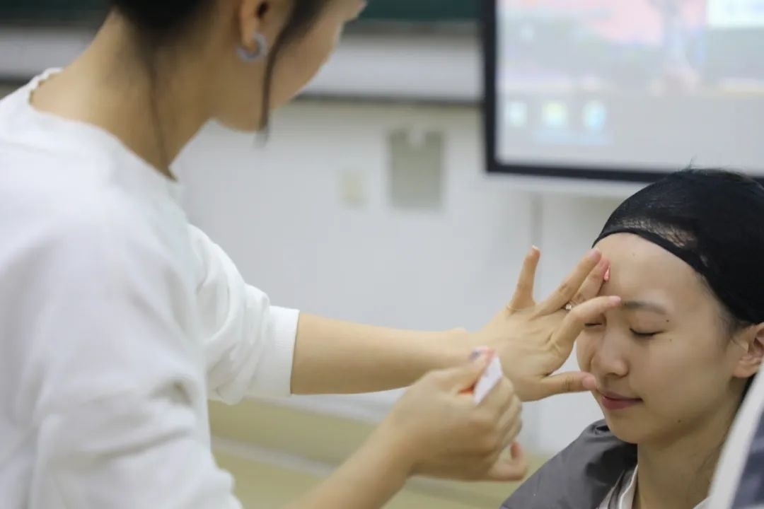 課堂上，一名學(xué)生在體驗(yàn)上戲妝。學(xué)校供圖