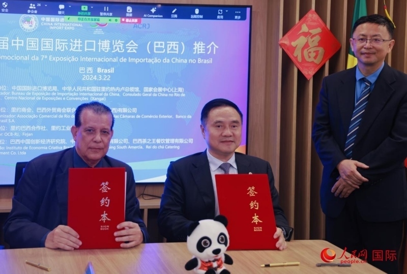 巴西外貿(mào)商會(huì)聯(lián)合會(huì)會(huì)長阿代爾·羅伯托（左）與中國國際進(jìn)口博覽局副局長吳政平（中）現(xiàn)場(chǎng)簽訂協(xié)議。人民網(wǎng)記者 宋亦然攝