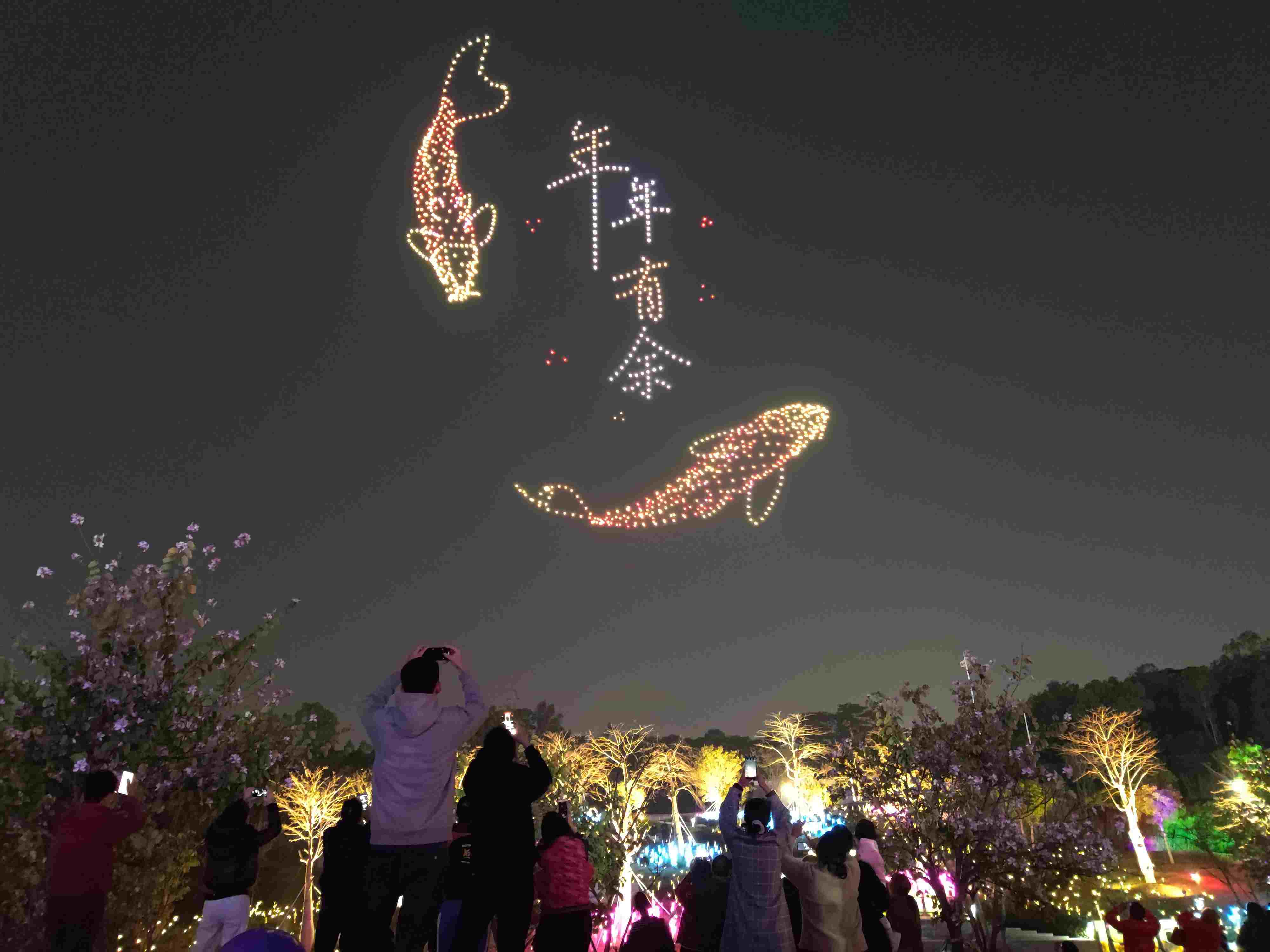 △ 2024年2月10日，深圳北站中心公園，春節(jié)主題無人機(jī)燈光秀引來眾多游客駐足觀看。