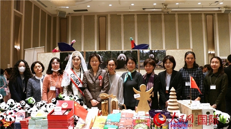 中國(guó)駐日本大使吳江浩夫人丁玥（左五）與使館人員在展位前合影留念。人民網(wǎng) 許可攝