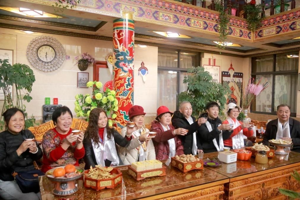 游客們?nèi)胱∶袼藓?，舉杯共飲酥油茶。新華社記者 邱星翔 攝