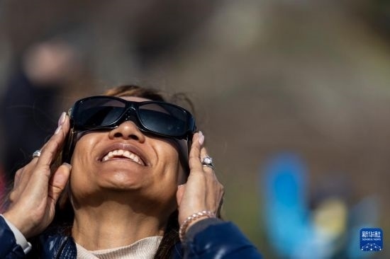 4月8日，一名女子在美國(guó)紐約州普拉茨堡觀看日食。新華社發(fā)（文森特·約翰遜攝）