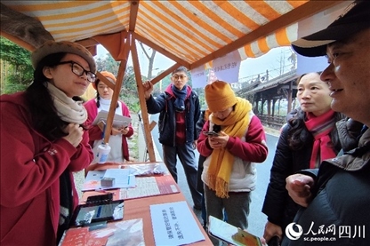 1月6日，“2024成都蒲江柑甜采摘節(jié)”上，記者見到了小萌（左一）和許多年輕人忙著做訪客接待、現(xiàn)場(chǎng)布置、票務(wù)核對(duì)、采摘服務(wù)等工作。人民網(wǎng)記者朱虹攝