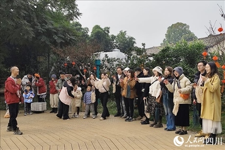 葉科（左一）給前來參與活動(dòng)的“柑爸柑媽”介紹生態(tài)種植果。人民網(wǎng)記者朱虹攝