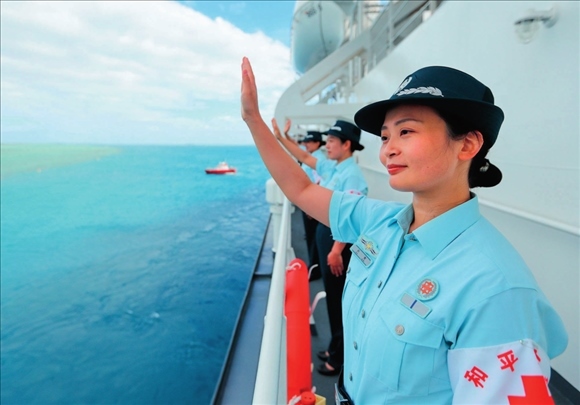 中國海軍“和平方舟”號醫(yī)院船結(jié)束訪問湯加時，任務官兵中的文職人員向歡送人群揮手告別（2023年8月4日攝）。徐巍攝/本刊