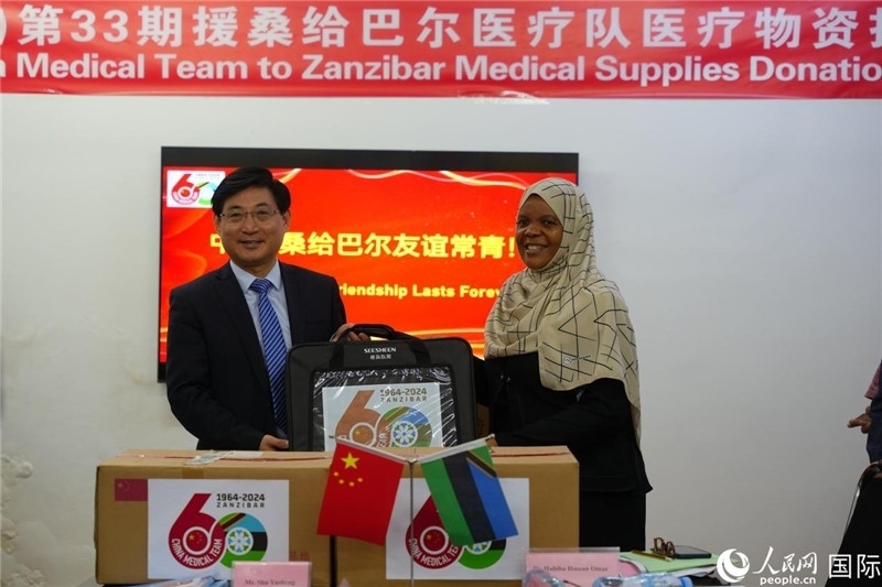 江蘇省蘇北人民醫(yī)院黨委書記束余聲捐贈物資與桑衛(wèi)生部首席秘書哈比巴。中國援桑醫(yī)療隊供圖