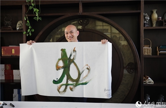 老撾駐華大使館三秘明君參加《五百筆·瀾湄合作》集體藝術(shù)創(chuàng)作。人民網(wǎng)王婧攝。