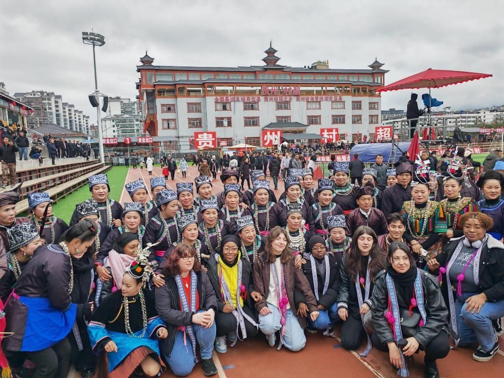 法國青年在“村超”賽場(chǎng)邊與參加表演的村民合影。新華社記者 羅羽 攝