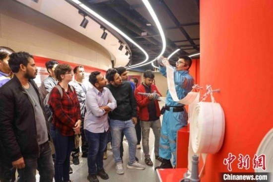 5月9日，工作人員指導(dǎo)留學(xué)生正確使用消防水帶。張鷹 攝