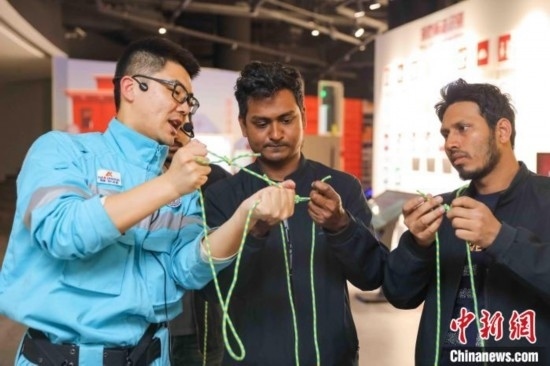 5月9日，工作人員指導(dǎo)留學(xué)生學(xué)習(xí)打繩結(jié)。張鷹 攝