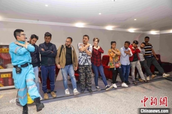 5月9日，工作人員指導(dǎo)留學(xué)生練習(xí)逃生技巧。張鷹 攝