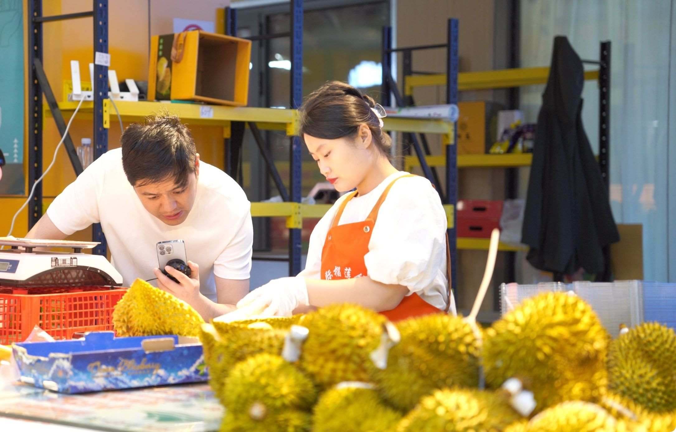 榴蓮商家正在通過(guò)手機(jī)直播銷售榴蓮。人民網(wǎng)記者申佳平 攝