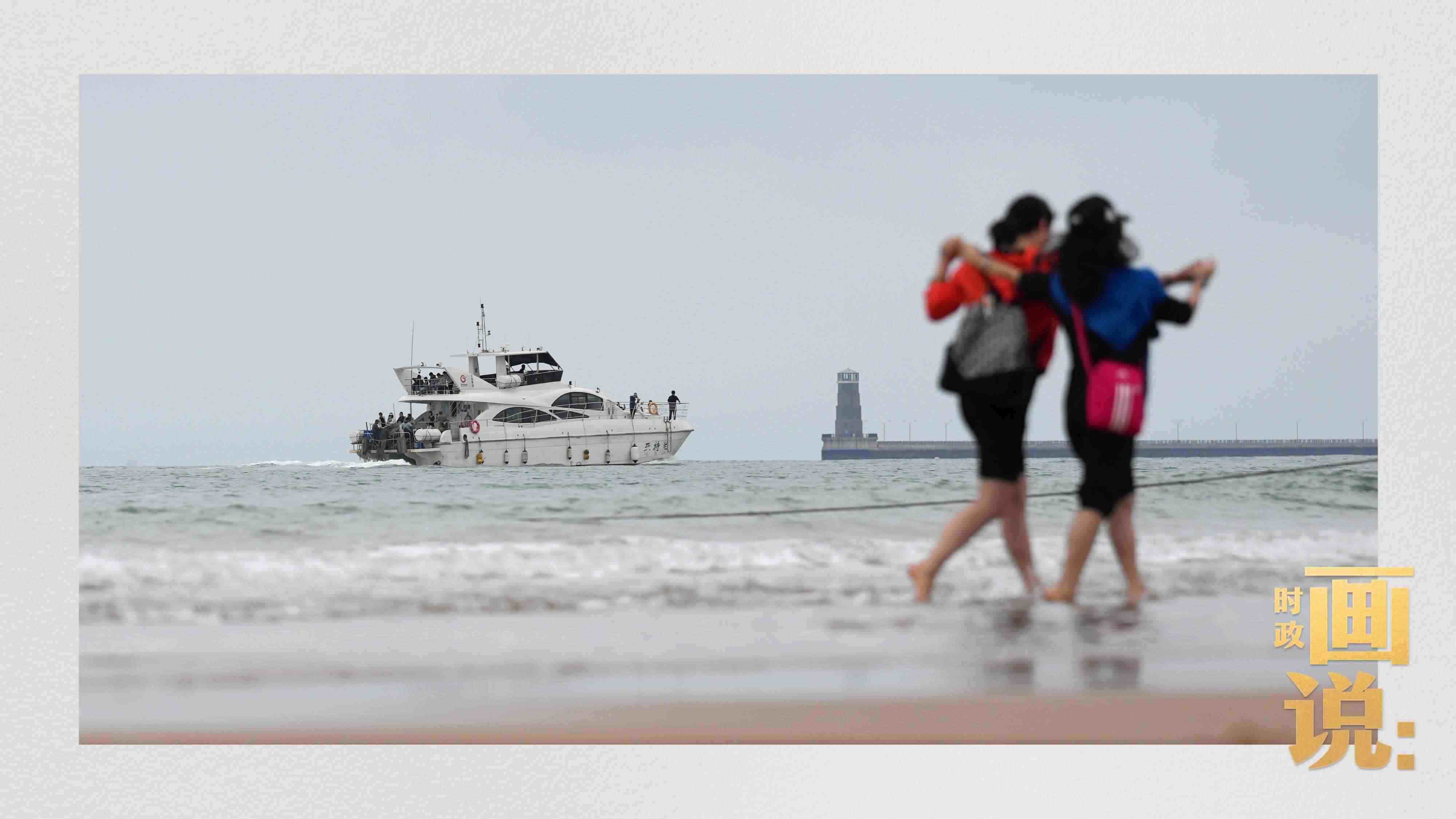 △日照陽光海岸綠道上的萬平口景區(qū)，一對游客在海浪中翩然起舞。