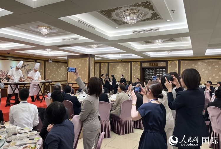 國(guó)家級(jí)非物質(zhì)文化遺產(chǎn)、全聚德片鴨工藝吸引代表團(tuán)成員拍照留念。