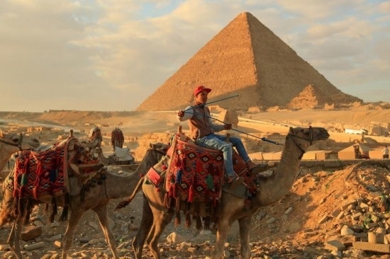 1月24日，商販騎駱駝離開埃及吉薩金字塔景區(qū)。新華社記者 隋先凱 攝