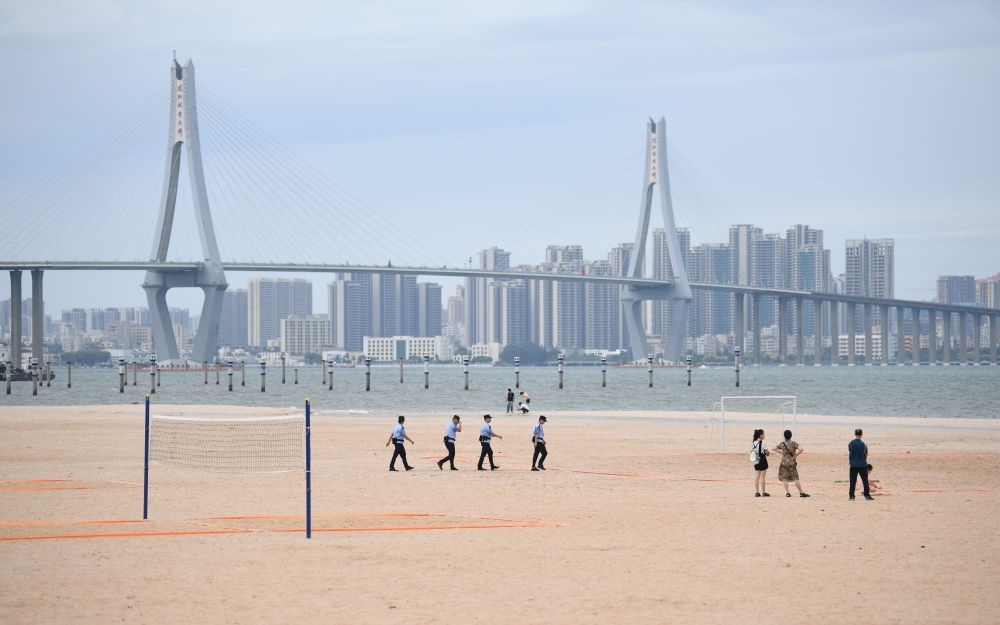 2023年7月17日，廣東湛江五環(huán)廣場(chǎng)的沙灘上，公安民警在執(zhí)勤巡邏。新華社記者 鄧華 攝