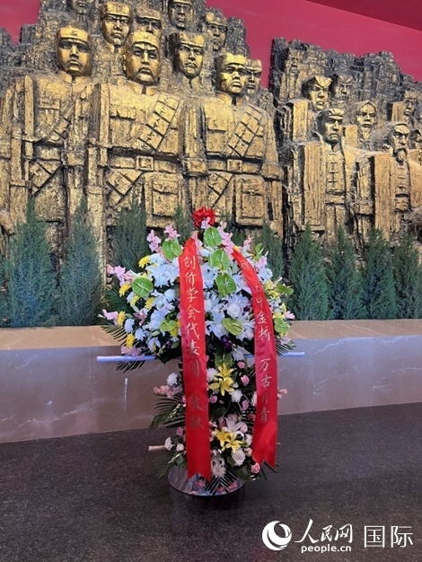 創(chuàng)價學(xué)會青年代表團(tuán)敬獻(xiàn)的花籃上，寫有“愿日中金橋萬古長青”。人民網(wǎng)記者 陳思攝