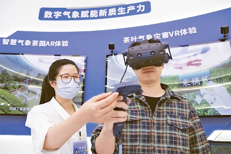 2024年5月23日，第七屆數(shù)字中國建設(shè)峰會(huì)現(xiàn)場(chǎng)體驗(yàn)區(qū)在福州海峽國際會(huì)展中心向?qū)I(yè)觀眾開放。本次現(xiàn)場(chǎng)體驗(yàn)區(qū)圍繞本屆峰會(huì)主題“釋放數(shù)據(jù)要素價(jià)值，發(fā)展新質(zhì)生產(chǎn)力”，設(shè)置“數(shù)字惠民”、“數(shù)字能力”、“數(shù)字基礎(chǔ)”、“數(shù)字生態(tài)”、“數(shù)字賦能”五大板塊。圖為一名觀眾（右）在數(shù)字氣象賦能新質(zhì)生產(chǎn)力展臺(tái)上進(jìn)行體驗(yàn)。 新華社記者 魏培全/攝