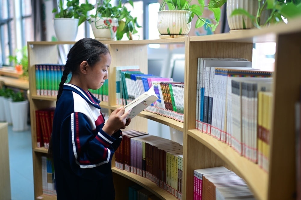 6月18日，果洛西寧民族中學(xué)學(xué)生尼東拉毛在圖書室看書。