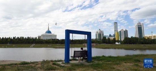 6月30日，一名女子在哈薩克斯坦首都阿斯塔納伊希姆河畔休息。新華社記者 王建華 攝