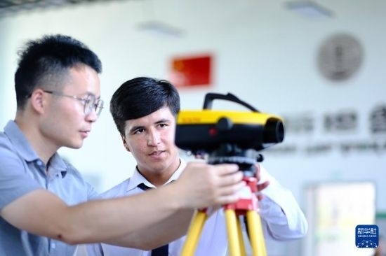 6月14日，在塔吉克斯坦首都杜尚別的魯班工坊，來自天津城市建設(shè)管理職業(yè)技術(shù)學(xué)院的老師（左）指導(dǎo)學(xué)生。新華社記者 鄭開君 攝