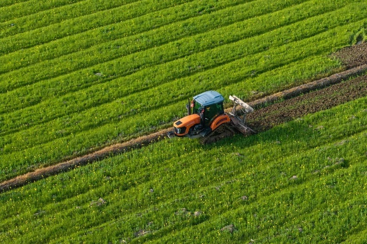 2024年3月19日，在湖南省常德市鼎城區(qū)謝家鋪鎮(zhèn)港中坪村，村民駕駛農(nóng)機(jī)翻耕田地（無人機(jī)照片）。新華社記者 陳思汗 攝