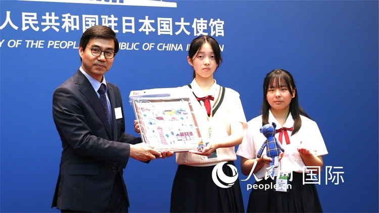 日本小大使向中國(guó)駐日本大使館臨時(shí)代辦施泳贈(zèng)送當(dāng)?shù)靥厣Y品。人民網(wǎng) 許可攝