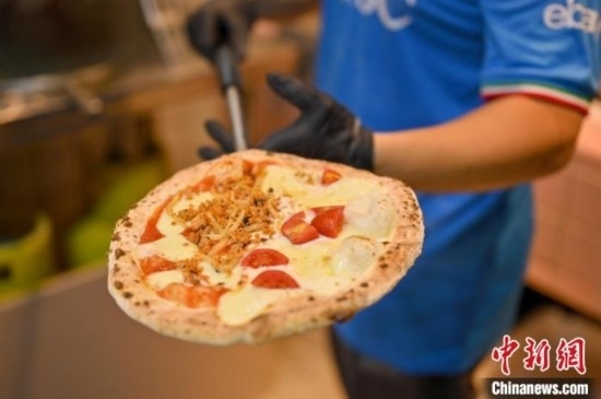 近日，韋榮耀展示他制作的“老友味”披薩。 俞靖 攝