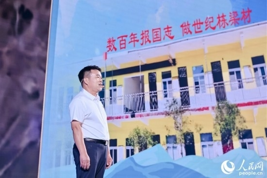 張玉滾分享用一根扁擔(dān)送孩子們走出大山的故事。人民網(wǎng)攝