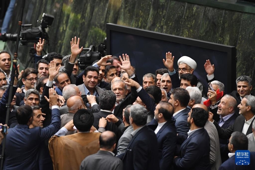 7月30日，在伊朗德黑蘭的伊朗議會(huì)，佩澤希齊揚(yáng)（中）離開(kāi)總統(tǒng)就職典禮現(xiàn)場(chǎng)時(shí)揮手致意。新華社記者 沙達(dá)提 攝