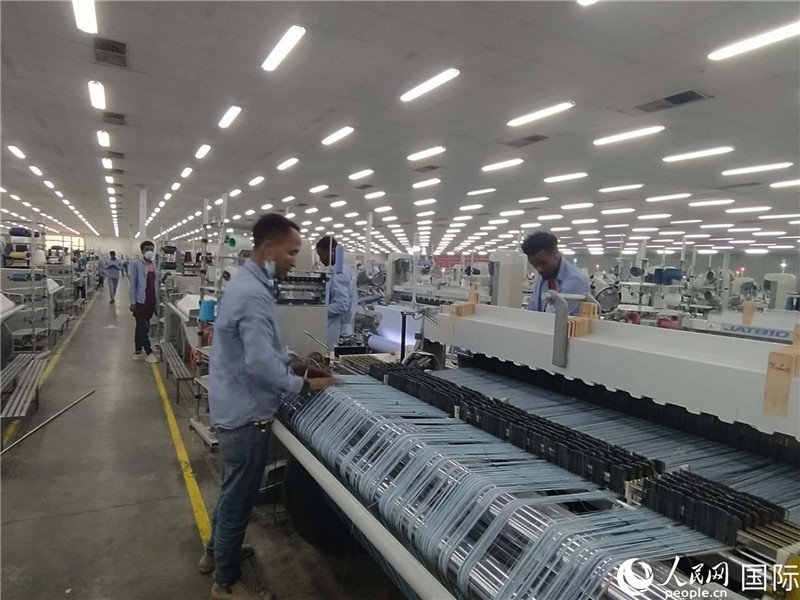 無錫金茂埃塞面料廠車間內(nèi)，當?shù)毓と苏谝唤z不茍地作業(yè)。人民網(wǎng)記者 黃培昭攝