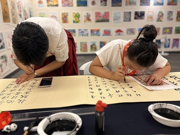 參加本次展覽的青少年在現(xiàn)場進(jìn)行書法創(chuàng)作。主辦方供圖