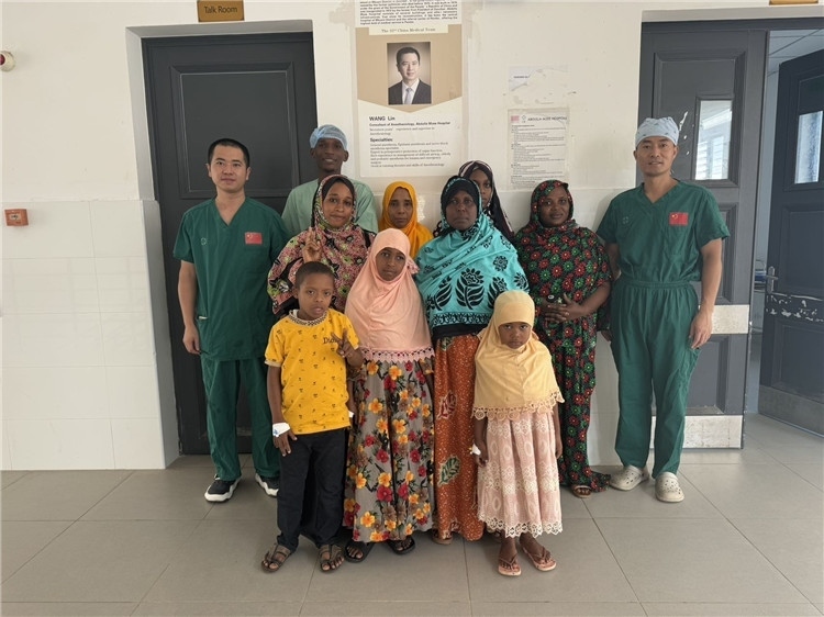 李廣（右一）和王林醫(yī)生與部分患者合影。中國援桑醫(yī)療隊供圖