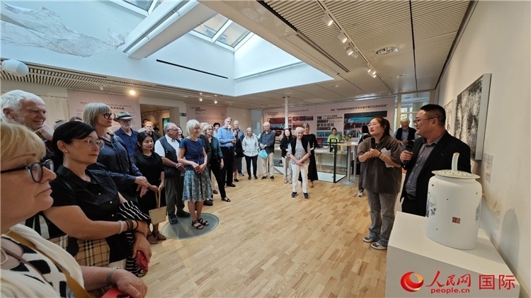 參展人、景德鎮(zhèn)陶瓷大學(xué)美術(shù)學(xué)院副院長邵長宗（右一）向來賓介紹參展作品。人民網(wǎng)記者 殷淼攝