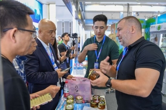 2023年8月23日，在第十四屆中國(guó)—東北亞博覽會(huì)東北亞商品館，俄羅斯參展商向參觀者介紹商品。