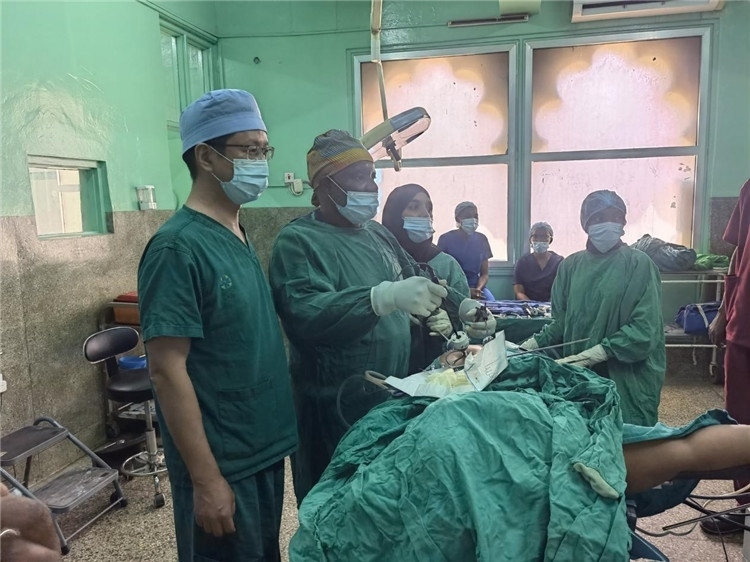 隊(duì)長蔣國慶（左一）關(guān)注當(dāng)?shù)蒯t(yī)生手術(shù)情況。中國援桑醫(yī)療隊(duì)供圖