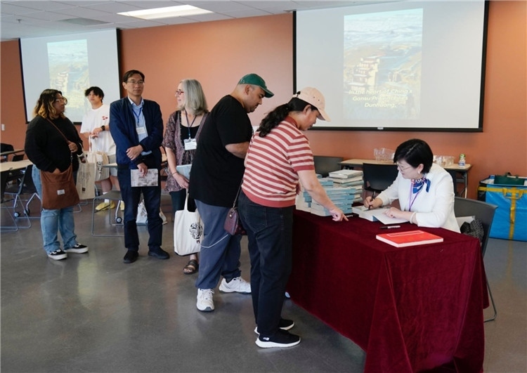 作者顧春芳在活動(dòng)現(xiàn)場(chǎng)簽名贈(zèng)書(shū)。羅先勇攝