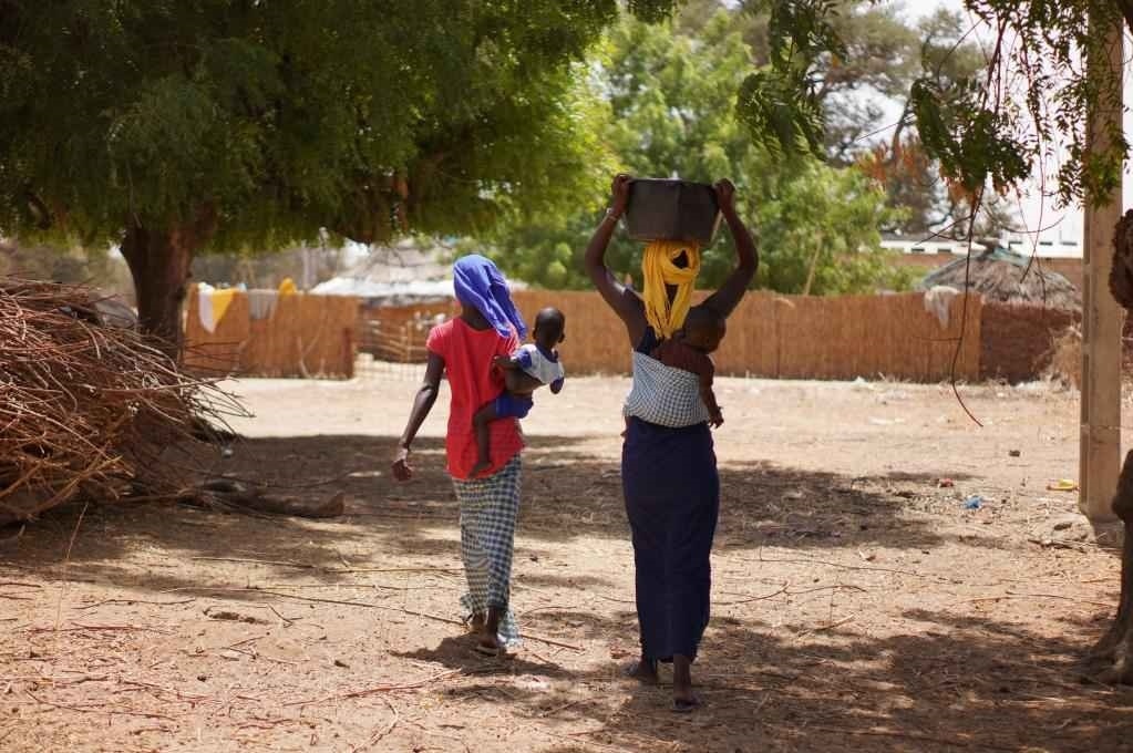 2023年3月20日，在塞內(nèi)加爾久爾貝勒區(qū)的泰內(nèi)富勒村，村民將取到的水運回家。新華社記者 王子正 攝