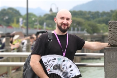 俄羅斯塔斯社執(zhí)行編輯葉夫根尼·扎多羅日內(nèi)在都江堰魚嘴拍照留念。（李佩藺 攝）