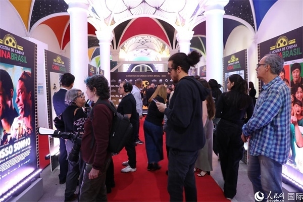 為期4天的第三屆中國－巴西電影展期間，來自中巴兩國的14部參展影片受到巴西電影愛好者和社會各界人士好評，圖為當(dāng)?shù)赜^眾在影展舉辦地巴西里約熱內(nèi)盧勞拉—阿爾維姆文化之家的迎賓廳欣賞參展電影海報。 人民網(wǎng)記者 陳一鳴攝