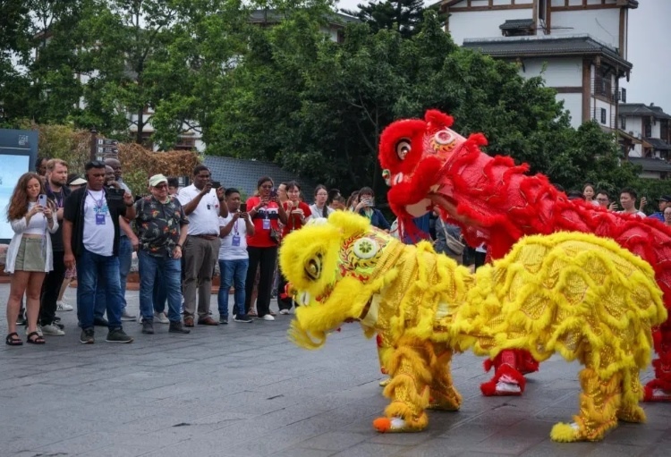 2024“一帶一路”媒體合作論壇聯(lián)合采訪調(diào)研行成員在樂山蘇稽古鎮(zhèn)觀看非遺舞獅表演。本報(bào)記者 伊霄攝