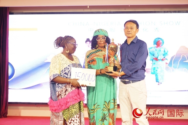 中國(guó)駐尼日利亞使館文化參贊兼中國(guó)文化中心主任李旭大（右）為最佳表現(xiàn)獎(jiǎng)?lì)C獎(jiǎng)（中）。人民網(wǎng)記者 姜宣攝