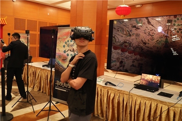 1、在本次活動的展覽現(xiàn)場，敦煌研究院與騰訊展示了“數(shù)字藏經(jīng)洞”和“尋境敦煌”等創(chuàng)新互動產(chǎn)品。圖為當(dāng)?shù)孛癖娡ㄟ^VR虛擬游覽洞窟。 人民網(wǎng)記者 李志偉攝