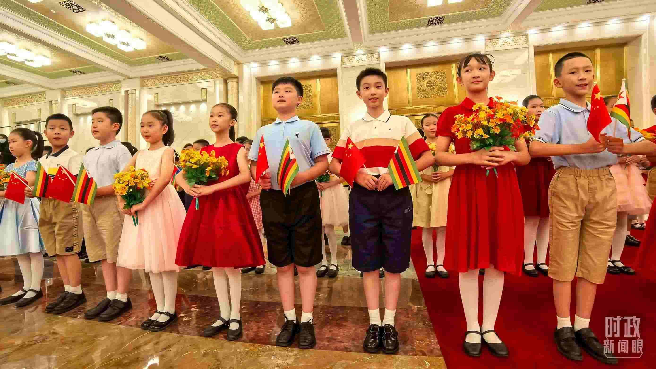 △現(xiàn)場歡迎津巴布韋總統(tǒng)訪華的青少年。（總臺央視記者鐘銳拍攝）