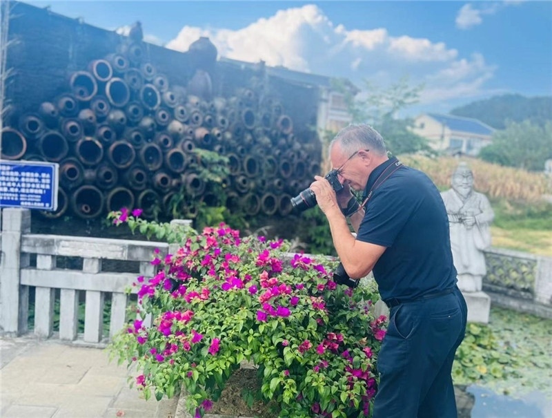 遠(yuǎn)處黔北民居錯(cuò)落有致，近處一只黑色的蝴蝶穿梭于粉紫色三角梅花叢間隙，與俄羅斯“大歐亞”總編輯弗拉基米爾·別列日內(nèi)赫的鏡頭玩起了捉迷藏，“你追我逃，不亦樂乎”。（張亞欣攝）