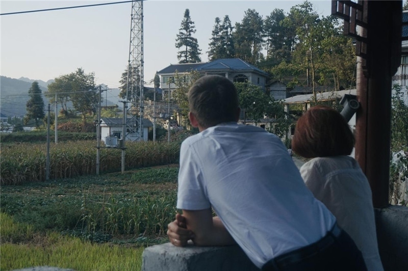 望得見山，看得見水，記得住鄉(xiāng)愁。每個(gè)人心中都有一個(gè)屬于自己的“花茂村”，在這方心田，走遍千山萬水，鄉(xiāng)音未改鬢毛衰。吉爾吉斯斯坦《比什凱克晚報(bào)》第一副總編輯妮娜·尼奇博洛娃與《中國(guó)與俄羅斯》雜志社社長(zhǎng)奧列格·別列日內(nèi)赫攝在花茂村民居屋檐下并肩佇立，眺望山水，尋覓鄉(xiāng)愁。（李光裕攝）