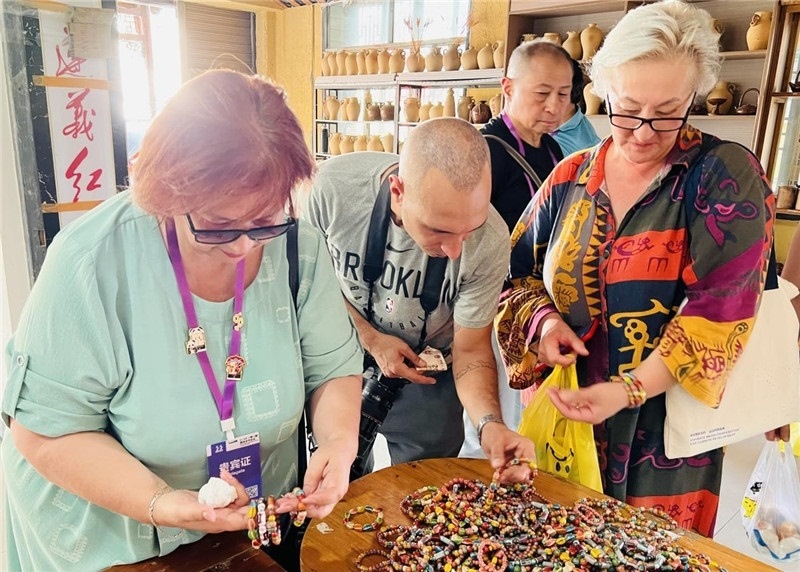 歐亞媒體考察團(tuán)成員在母氏陶藝館內(nèi)挑花了眼，色彩絢麗、質(zhì)地均勻的陶藝手串讓他們愛不釋手?！斑@里的東西都太實(shí)惠了！”塔吉克斯坦《索格特真理報(bào)》政論部主任娜塔利婭·多羅費(fèi)耶娃說?；宓奶厣a(chǎn)品物美價(jià)廉，讓考察團(tuán)成員為家人好友買到了心儀的禮物，也為此次以四川成都為起點(diǎn)，路經(jīng)南充、廣安至貴州遵義的考察行程畫上了圓滿句號(hào)。（張亞欣攝）